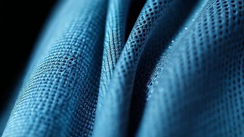 photorealistic, professional photography, 8K, cinematic lighting, sharp focus, depth of field, shot on a high-end DSLR. A close-up, macro shot of two distinct activewear fabrics side-by-side. One fabric shows a tight, dense weave, appearing less breathable. The other shows a visible, airy, moisture-wicking texture with microscopic pores, subtly shimmering with a hydrophobic quality. The lighting emphasizes the texture differences.