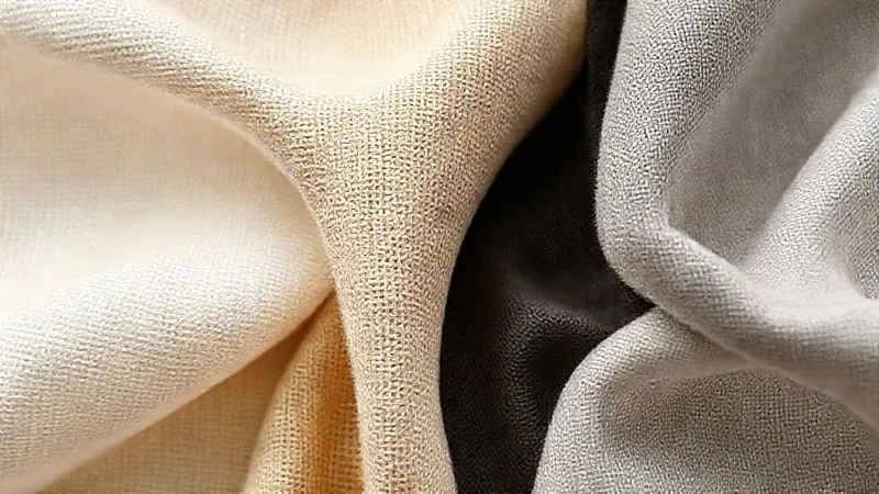 A close-up, photorealistic image showcasing various sustainable fabric swatches: a tightly woven organic cotton twill, a textured hemp canvas, a smooth Tencel Lyocell knit, and a subtly textured recycled polyester. The fabrics are arranged to highlight their distinct textures and weaves, with soft, natural lighting. Professional photography, 8K, cinematic lighting, sharp focus, depth of field, shot on a high-end DSLR.